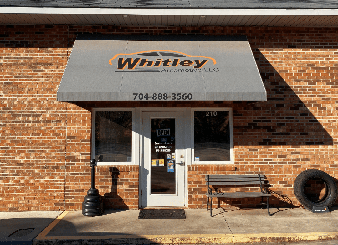 Front door with signage at Whitley Automotive auto repair in Locust, NC.
