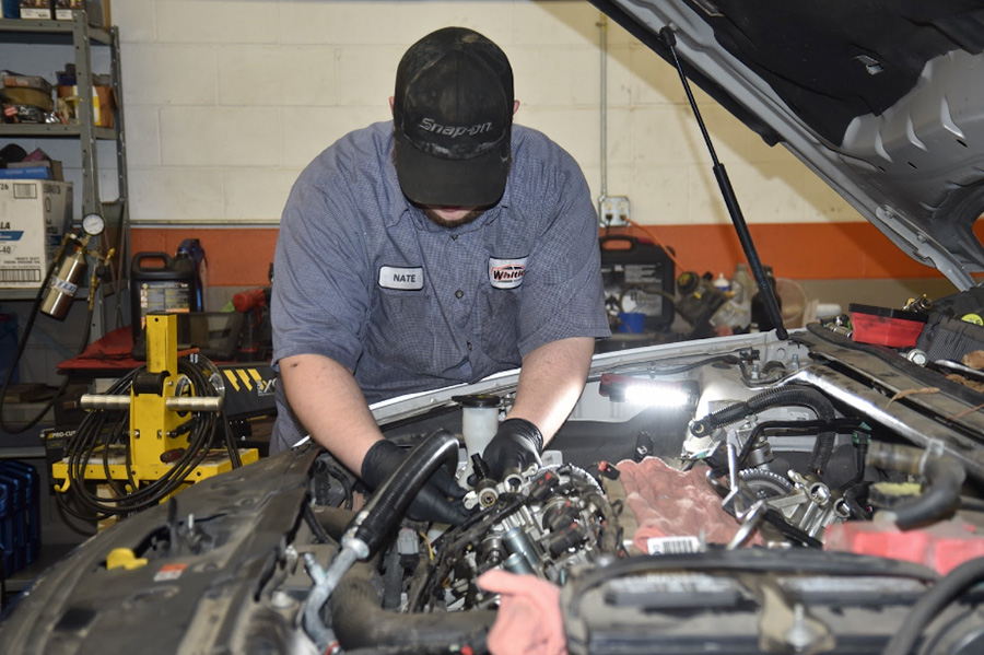 My car is acting strange: which services do I need at Whitley Automotive in Marshville, NC. Image of Whitley Automotive technician working on a truck engine in shop