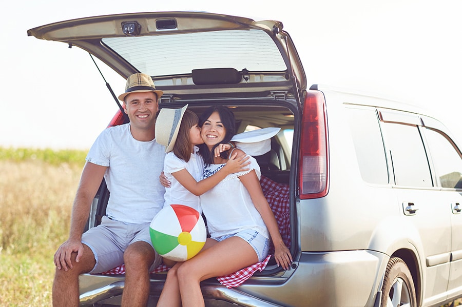 A happy family has a car on a summer trip. Concept image of “Pre-Trip Inspection: Prepare Your Car for Summer Road Trips” | Whitley Automotive in Locust, NC.