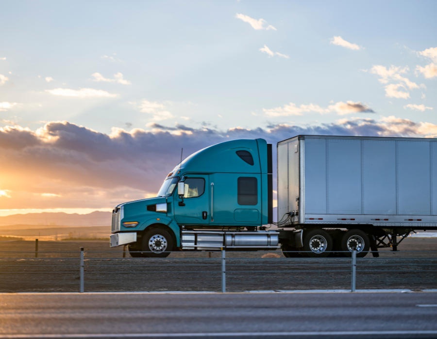 Trailer subscription services for fleet management in Locust, NC. Image of a blue semi-truck with a trailer on the highway at sunset, highlighting the efficiency and flexibility offered by subscription services.
