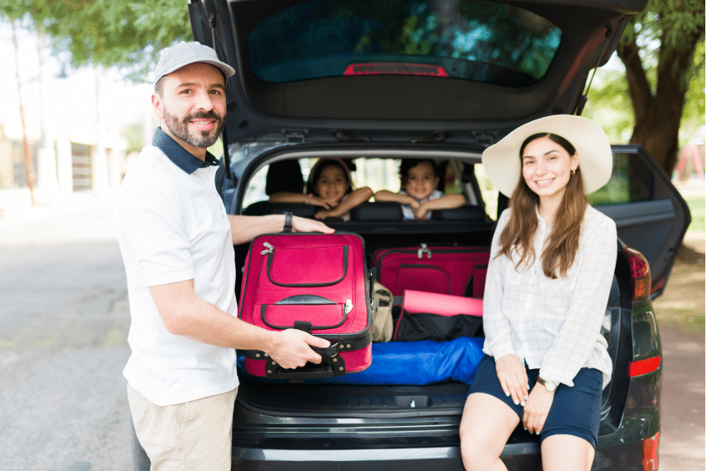 Car Maintenance Checklist in Locust, NC by Whitley Automotive. Image of a family loading luggage into the back of an SUV, highlighting safe and reliable vehicle readiness for long-distance travel.