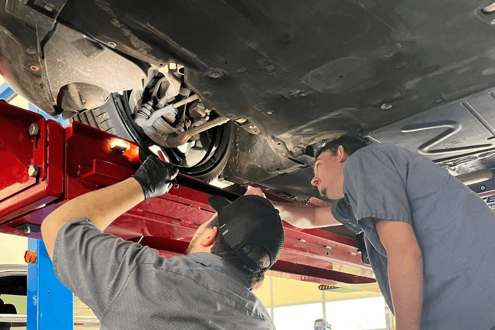 Car check, auto repair in Locust, NC at Whitley Automotive. Image of experienced technicians inspecting a vehicle's suspension and undercarriage during a comprehensive automotive inspection.
